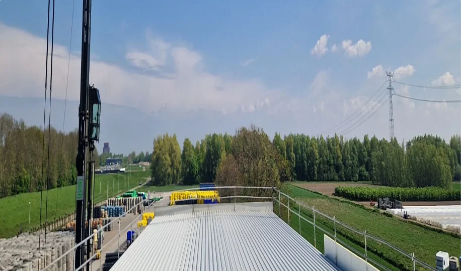 Uitzicht over industrieterrein en weilanden vanaf dak