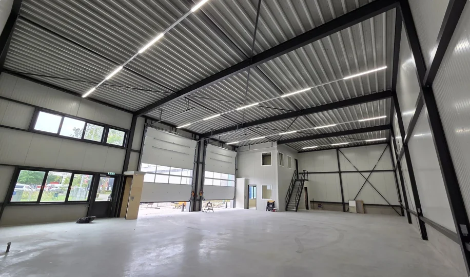 Interieur van ruime bedrijfshal met kantoorunit
